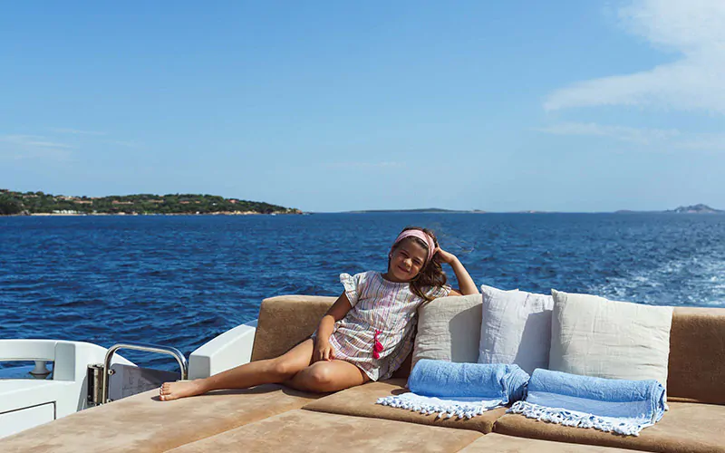 a little girl sitting on a yacht