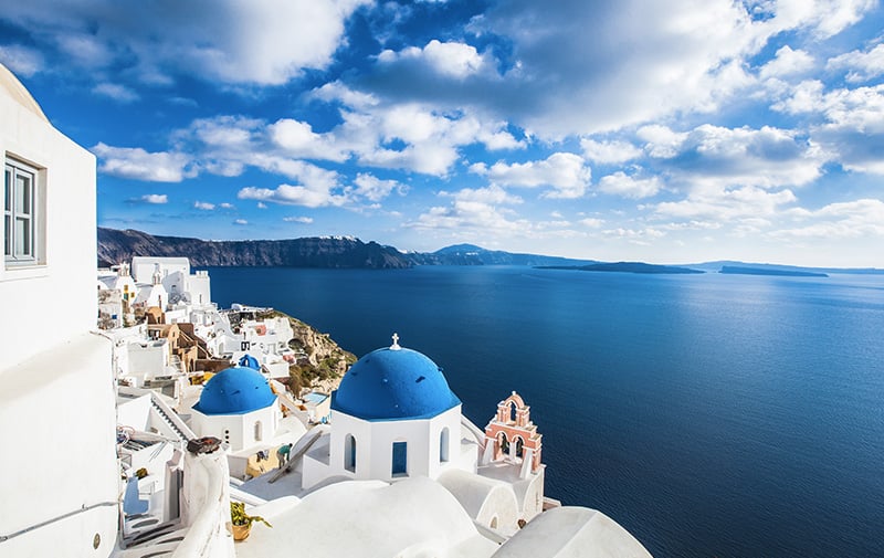 White traditional houses overlooking the blue waters of the greek cyclades